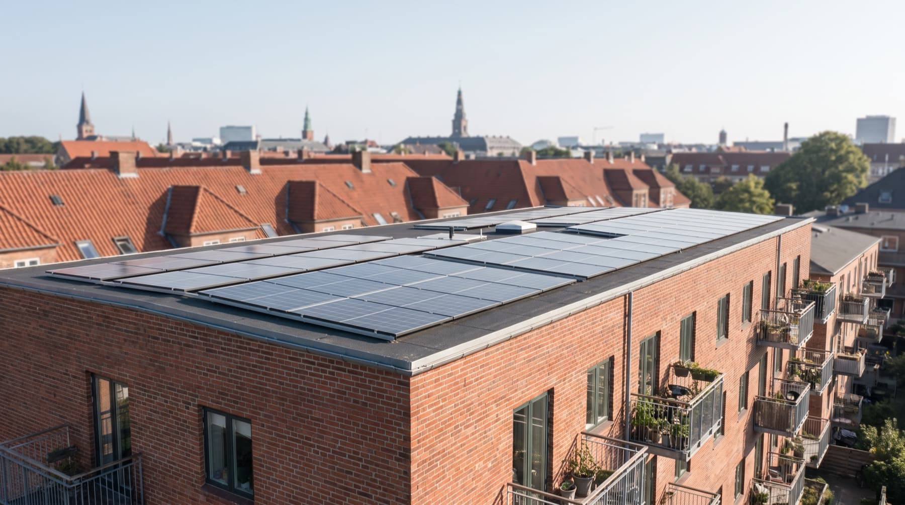 Solpaneler på et københavnsk tag i klart morgenlys